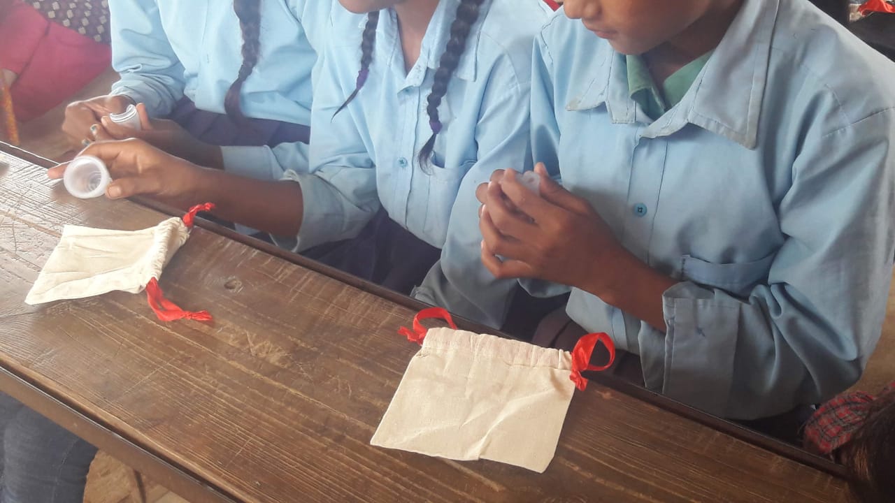 Girls with our Ruby Cup menstrual cups in a menstrual education workshop