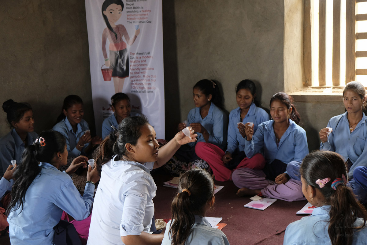 una chica en Nepal enseña la copa menstrual