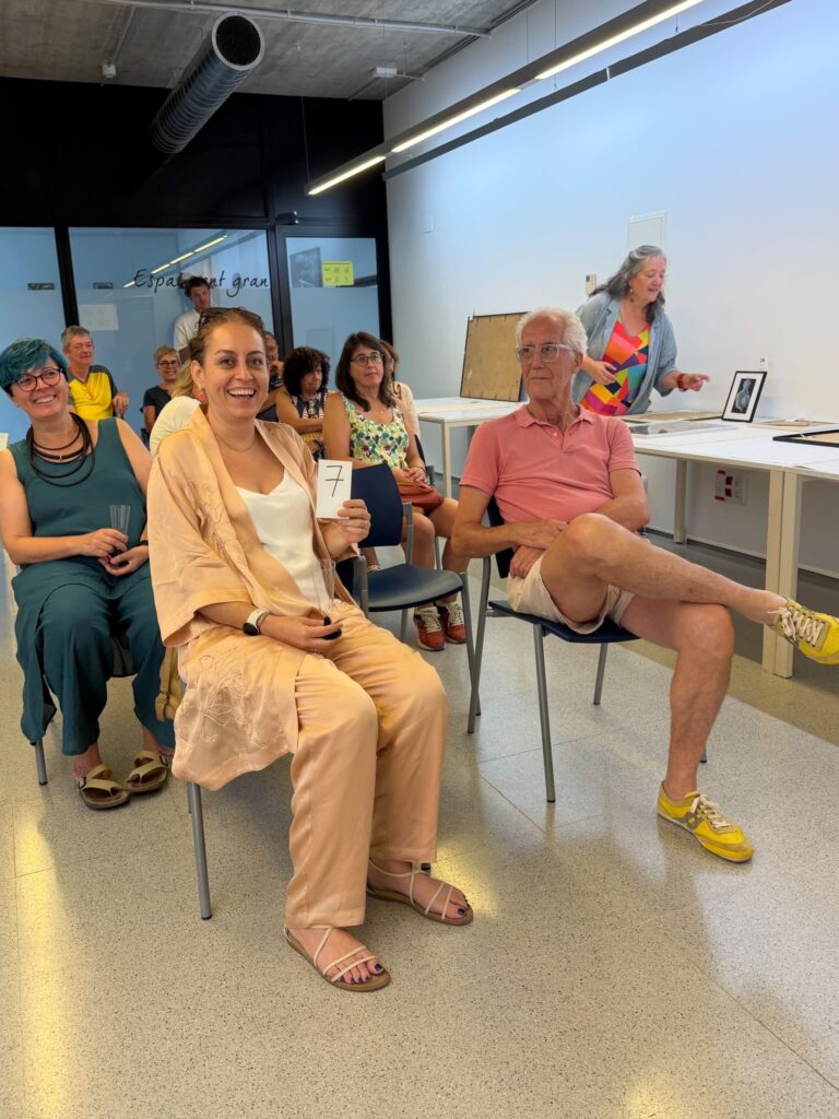 Participant holding bidding number 7 during the charity art auction in Ullà